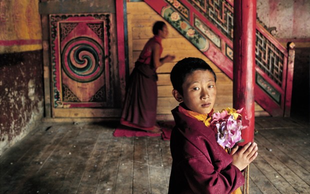 Steve McCurry - Giovane monaco con fiori, Larung Gar, Kham, Tibet, 2000 © St. Moritz Art Masters 2013