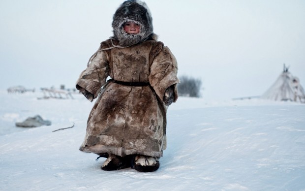 A Young Nenets boy plays in -40 degrees on Yamal in the Winter in Siberia.