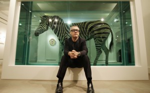 Damien Hirst posa di fronte alla sua opera The Incredible Journey presso la sede londinese della casa d'aste Sotheby's, nel 2008