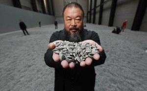 Ai Weiwei mostra alcuni dei "Sunflower Seeds" in porcellana che compongono l'omonima installazione in mostra alla Tate Modern di Londra, dall'ottobre del 2010 a maggio 2011 (Photo by Peter Macdiarmid/Getty Images)