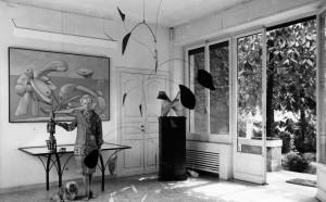 Peggy Guggenheim nell'ingresso della sua residenza di Venezia. Appesa al soffitto, una scultura di Alexander Calder del 1941, mentre alle spalle della collezionista si vede un dipinto di Picasso del 1937 (Photo by Keystone/Getty Images)