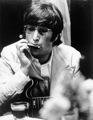 John Lennon nel giugno del 1966, mentre suona l'armonica (Photo by Keystone Features/Getty Images)