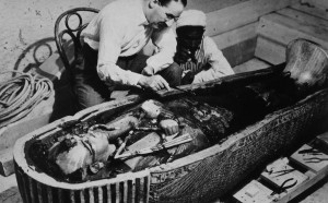 Howard Carter and an Egyptian workman examine the third coffin of Tutankhamun made of solid gold, inside the case of the second coffin. October 1925. Photographed by Harry Burton. INTERFOTO / Alamy Stock Photo
