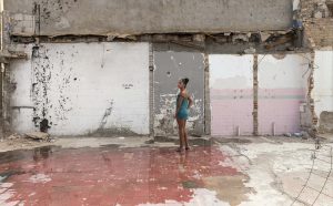 Teresa Margoles Pista de baile de la discoteca "Tlaquepaque" (Pista da ballo della discoteca"Tlaquepaque"), 2016Stampa su carta cotoneProstituta transessuale in piedi sul pavimento della pista da ballo del club demolito a Ciudad Juárez, Mexico45x64,5 cm, con corniceCourtesy dell’artista