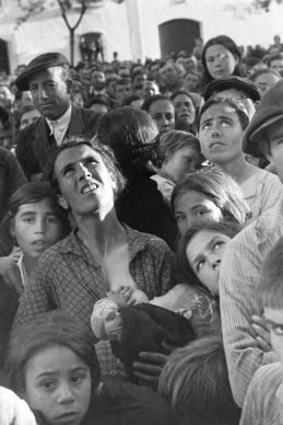 Vrouw met een  baby aan  haar  borst  tijdens een bijeenkomst  over landhervormingen, bij  Badajoz, Extramadura, Spanje, 1936 © Chim (David  Seymour), Magnum  Photos. Courtesy  Chim  Estate