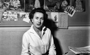 Ritratto di Camilla Cederna che siede fiera alla sua postazione di lavoro, con numerosi ritagli e fotografie appesi al muro alle sue spalle; la giornalista e scrittrice, apprezzata per i suoi articoli sul settimanale L'Europeo, ha recentemente dato alle stampe il suo primo libro, Noi siamo le signore. Milano (Italia), maggio 1958.