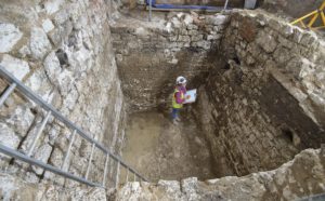 A MOLA archaeologist recording a 15th century cesspit uncovered in the basement of the Courtauld © MOLA