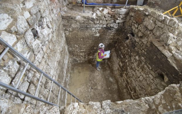 A MOLA archaeologist recording a 15th century cesspit uncovered in the basement of the Courtauld © MOLA
