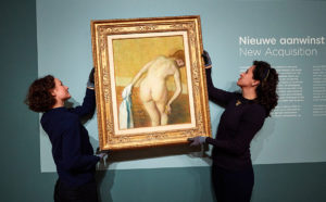 Curator Fleur Roos Rosa de Carvalho puts Woman Bathing by Edgar Degas up on the wall in the Van Gogh Museum, together with an art-handler. Photo: Jan-Kees Steenman
