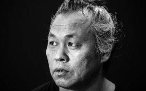 VENICE, ITALY - AUGUST 27: (EDITORS NOTE: Image has been converted to black and white) Director Kim Ki-duk attends a portrait session for his film 'One on One' during the 71st Venice Film Festival on August 27, 2014 in Venice, Italy. (Photo by Franco Origlia/Getty Images)