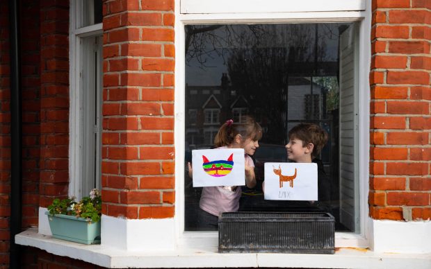 Artwork depicting animals, created by (left to right) Romey and Iggy is displayed in the windows of a row of houses in Acton, London. Photo David Parry/PA Wire