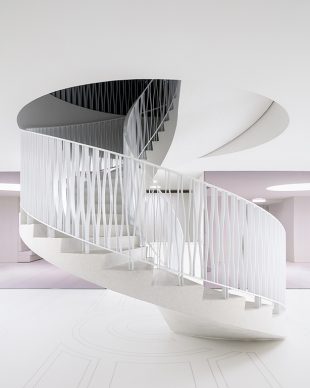 Royal Museum of Fine Arts, Anversa by KAAN Architecten. The circular staircase seen from the ground floor, the mosaic on the floor is a contemporary interpretation of the original one located in the entrance hall, right above © Stijn Bollaert